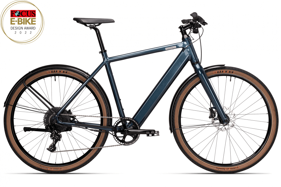 Ein blaues E-Bike mit braunen Reifen und Scheibenbremsen, aufgenommen von der Seite. Es befindet sich ein Logo "Focus E-Bike Design Award" oben links im Bild.